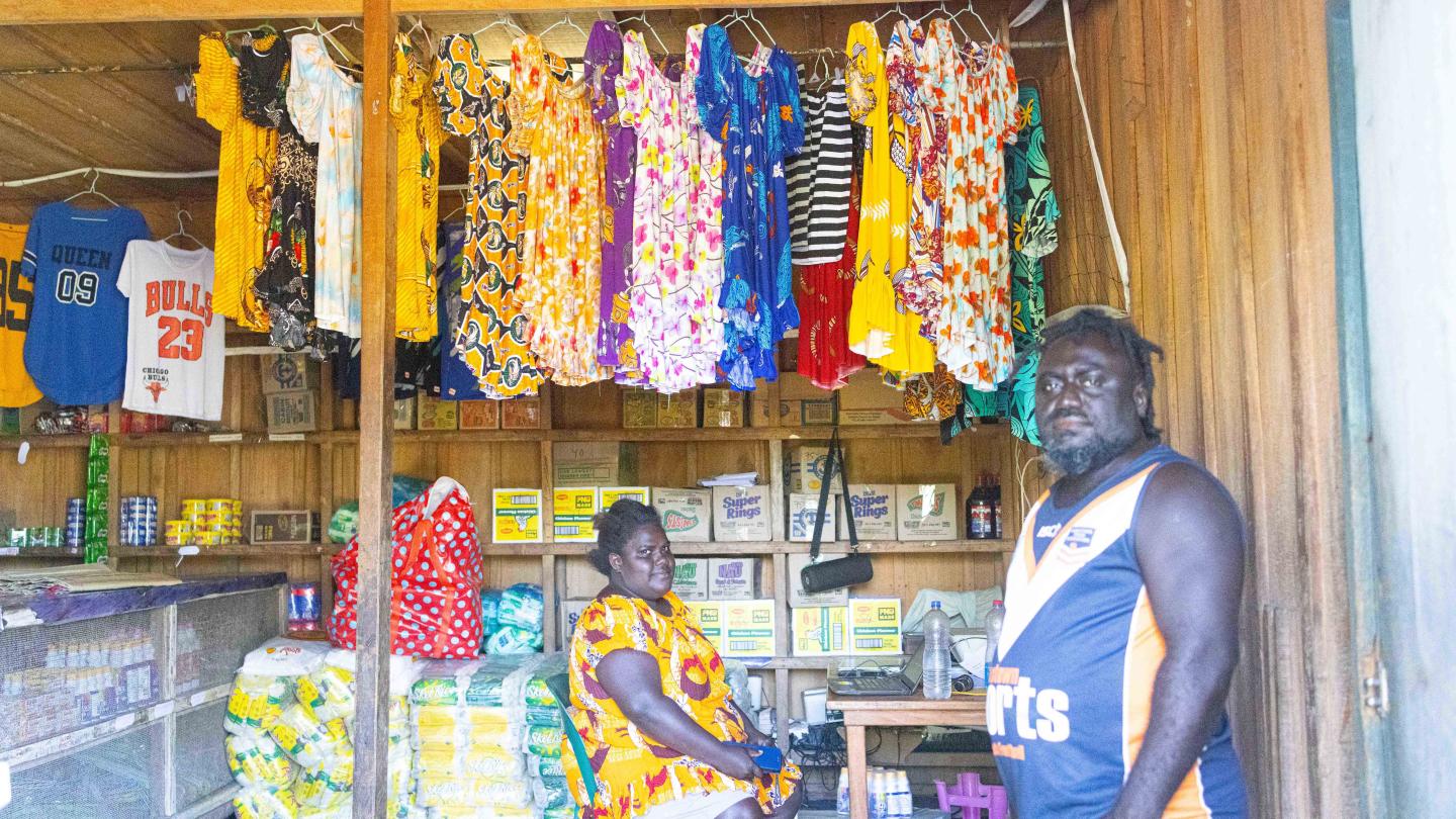 Amalanie sitted and husband posing for a photo inside their shop