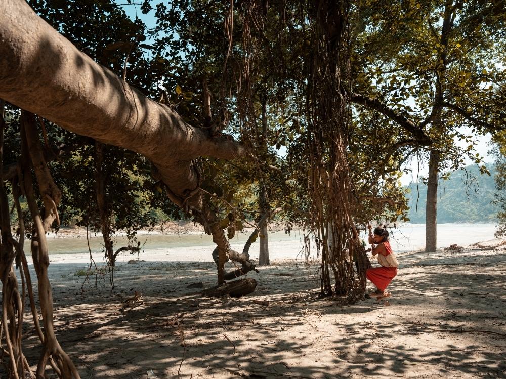 Geeta shows how she used to play swinging by the tree with her friends.