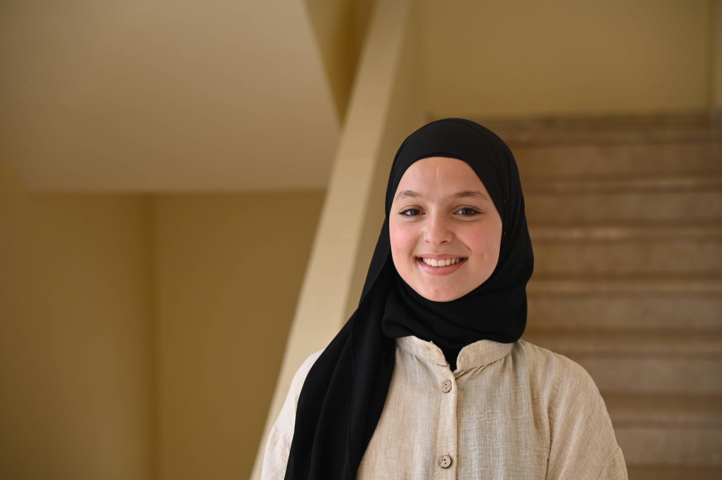 Hazar, 14, smiles while standing inside a learning centre in Wadi Khaled, Akkar.