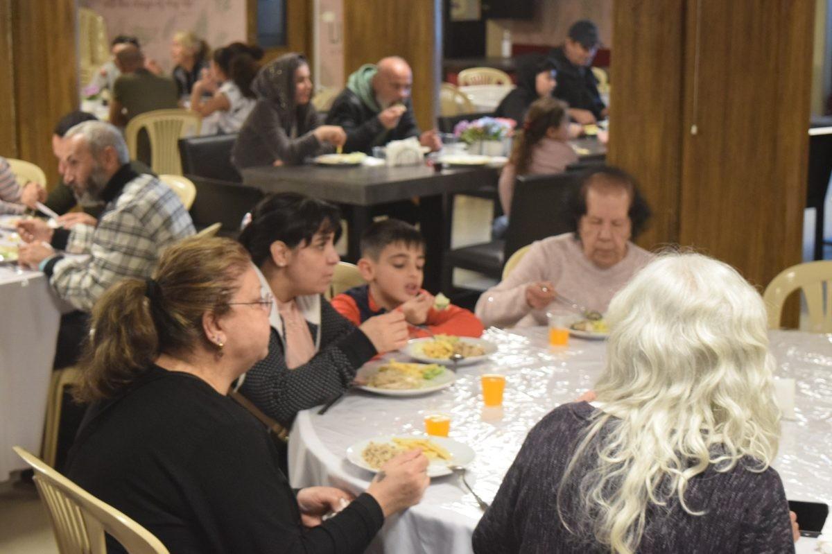 Displaced families share a meal at Mutual Faith’s community