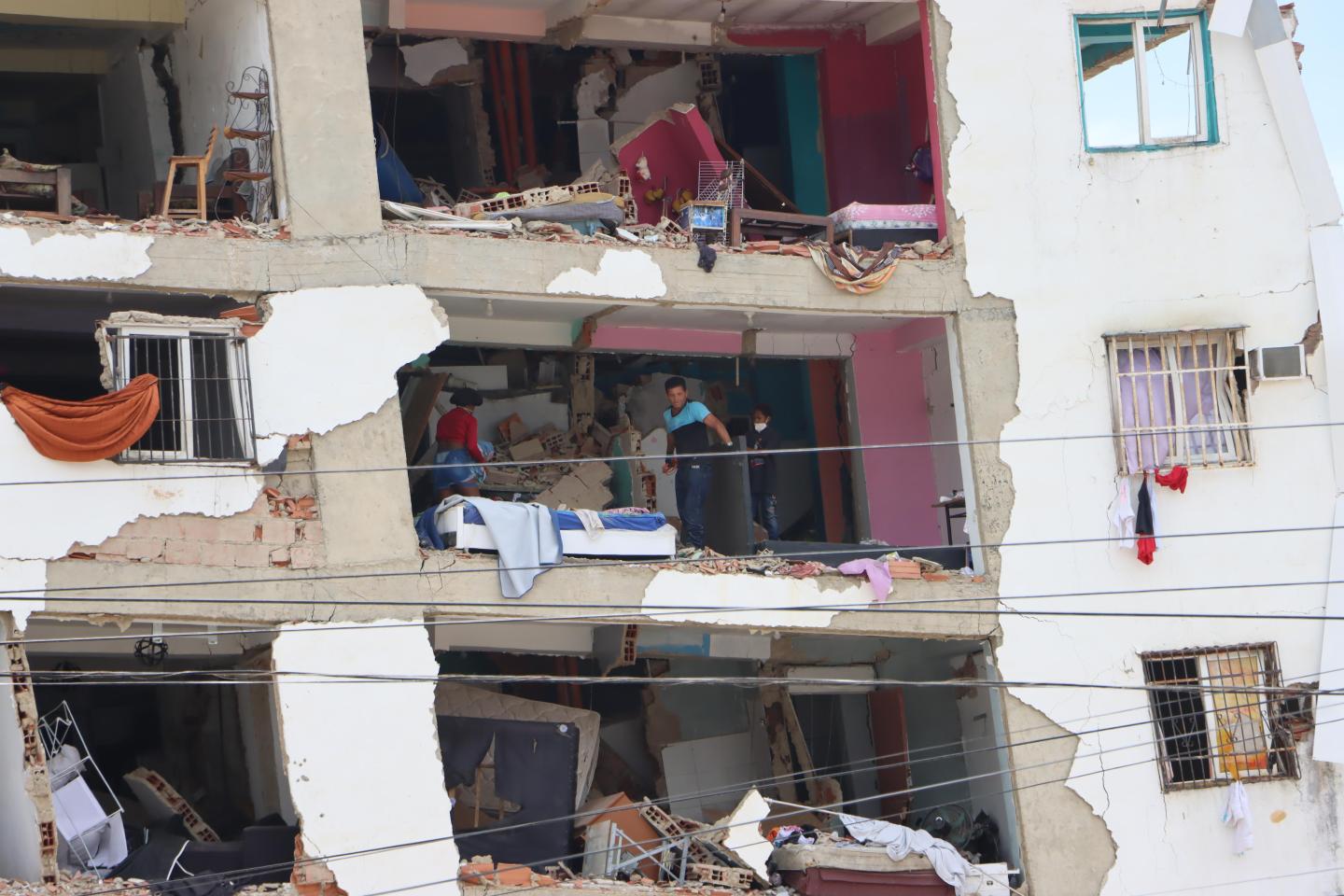 Residents inspect the remains of a heavily damaged apartment building. Venezuela 2026.