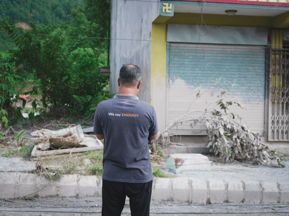 Jiban stands in front his home 
