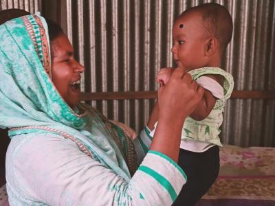 Mother who learned about exclusive breastfeeding smiles and plays with her health baby in Bangladesh
