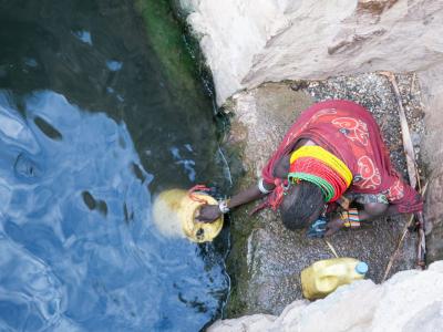 An elderly woman fetches water in Northern Kenya amid the drought and water streses