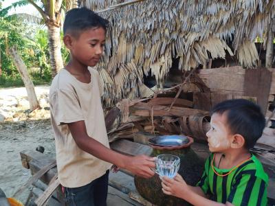 Kaung shares water to his neighbor child