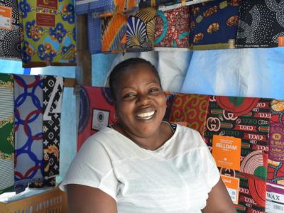 Mamie, mother of five and entrepreneur, stands in her clothing shop in Kinshasa, DRC