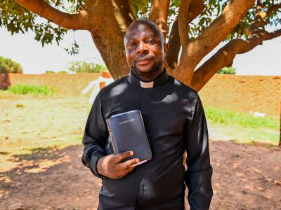 Pastor Elysée holding a bible