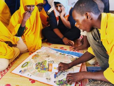 Children play an innovative board game designed to help Somali children