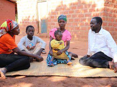 Xito's family interacts with World Vision staff member, Benedita, and explains her how they feel now with a solid, brick-built house 