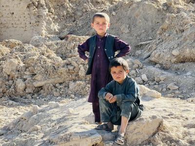 Two little boys sitting on the damage after the flood
