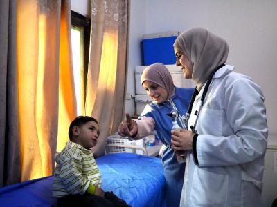 A doctor is providing health care to a child in a health center supported by World Vision
