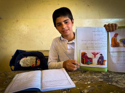 Muthana at his class showing us his text book. Narmeen Ali, © World Vision 2025.