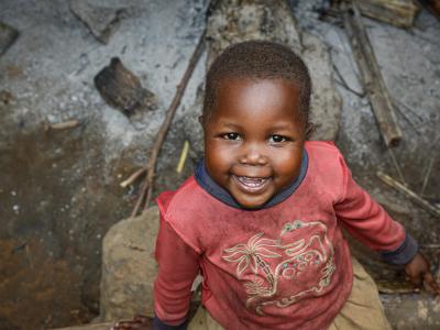 4-year-old Hortense smiles and plays outside her house.