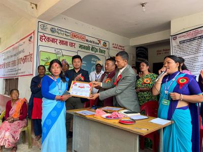 A FCHV receives appreciation letter for declaring the health facility a Nutrition-Friendly Health Facility