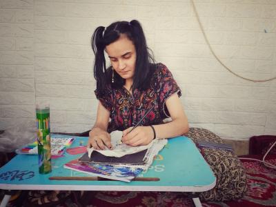 Huda getting into her world of imagination while drawing in Rashad. Ziryan Kameran© World Vision 2025.