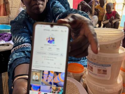 Aïssata Diarra, president of the Hodere Pinnal cooperative in Nouakchott, displays her TikTok account while surrounded by processed cereal products.