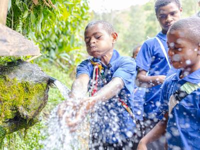 Children from a local school in Nipa Kutubu enjoy clean drinking water at a nearby water point. A heartwarming sign of community progress and improved access to safe water.