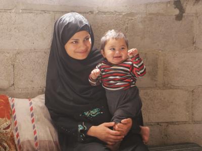 Shaima happily sitting with her now healthy son. 