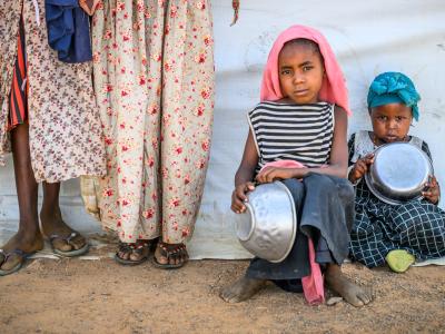 Children patiently waiting with empty bowls as food aid is distributed – Chad - Farchana Refugee Camp