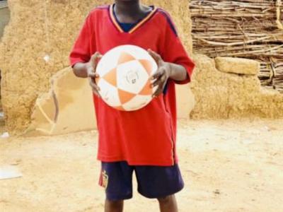 Issoufou tenant fierement le ballon recu de la part World Vision