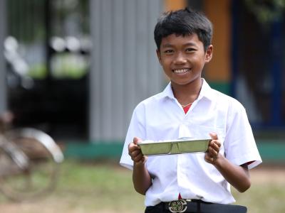 A boy enjoys his school meal. Kampong Thom province, Cambodia