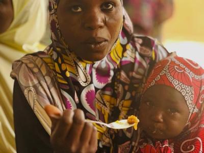 Aichatou, here at the community nutrition center, is feeding her child with a dish prepared at the center.