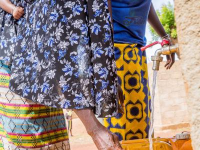 A mother draws water from a tap built by World Vision 