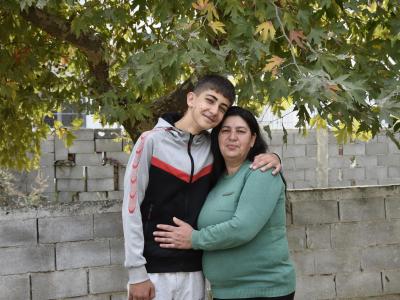 Mother and son hold each other while lookin gat the camera