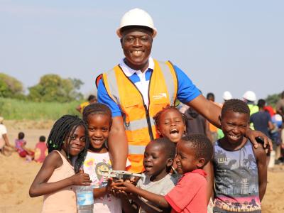 Amílcar Checo alongside the children who inspire his work.