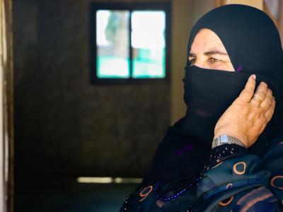 A Lebanese woman wearing a head scarf looks off into the distance 