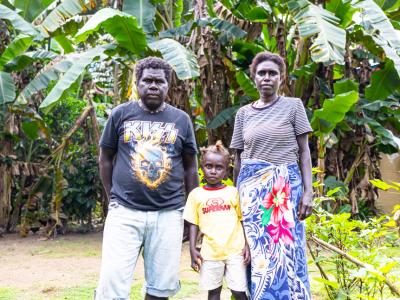 The family standing next to their backyard gardening