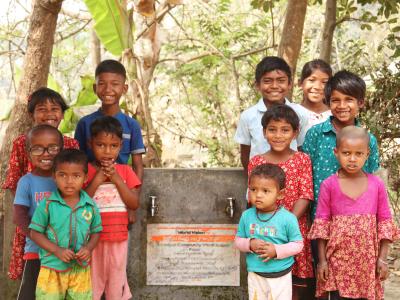 Community children standing in front of a World Vision Bangladesh water point in Binodpur village.
