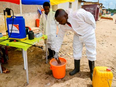 Two health workers mixing chlorine 