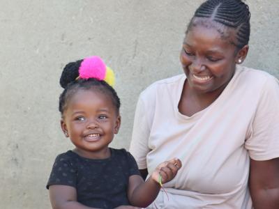 Qondile smiling with her daughter after a routine visit from a rural health motivator. 