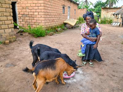 Mujinga at her home place in front of her goats