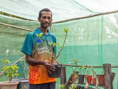William proudly posing for a photo showcasing his backyard nursery