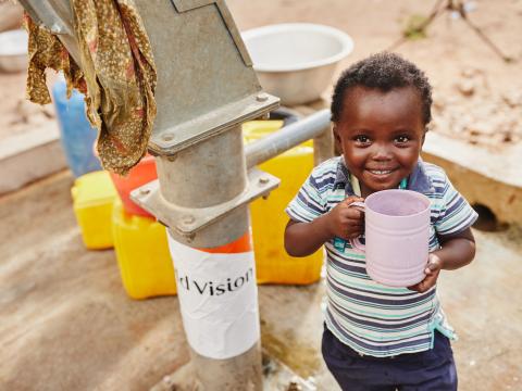 A boy in Ghana drinks water from a World Vision well. 