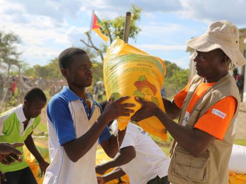 A World Vision employees gives food to people during a disaster
