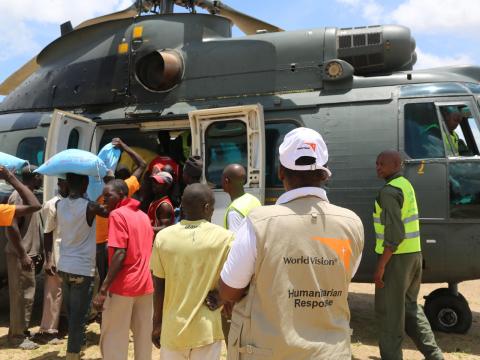 World Vision employees and locals getting food from a helicopter