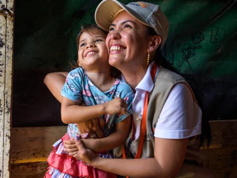World Vision staff hugging girl