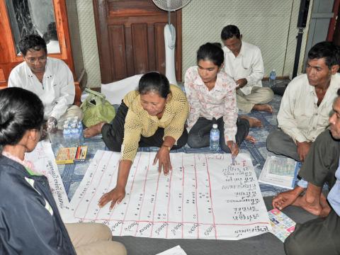 Group of Khmer adults sitting on the floor disaster reduction planning, Cambodia.