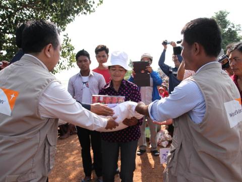 World Vision Cambodia staff members distributing emergency resources to community member in flood affected Cambodia.