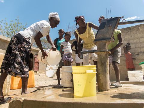 A group of people at a water well in Haiti