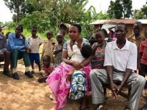 Couple sits on a bench in the Democratic Republic of Congo with their young child