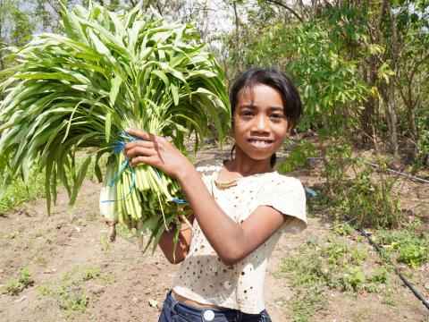 A little girl holding a crop