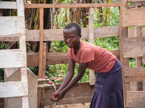 Naomie, 12, pupil at a local primary school drinking water at Iyobora water spring built by World Vision.