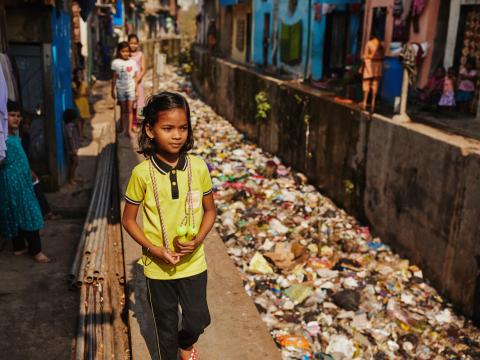 An image of a girl walking next to trash
