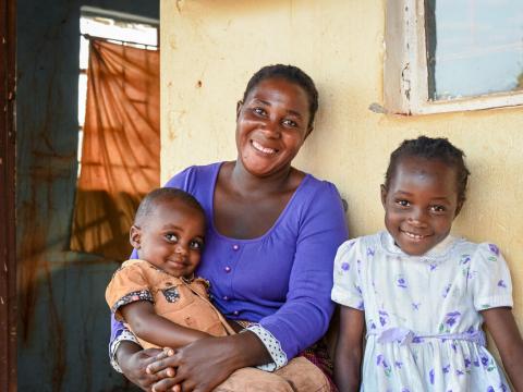 Maigalita, 33, with her children, 8-year-old Romance who was born before the health facility was equipped with water and electricity, and 2-year-old Daniel who was born in the new facility equipped with clean water by World Vision.