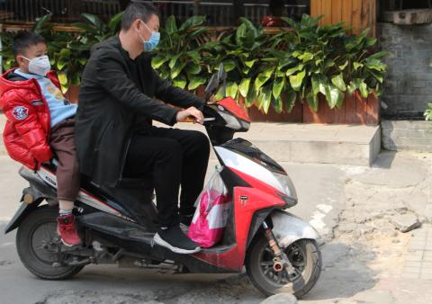 Child and dad in masks on a bike