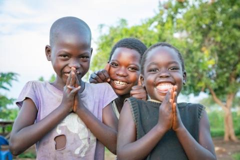Children praying and smiling